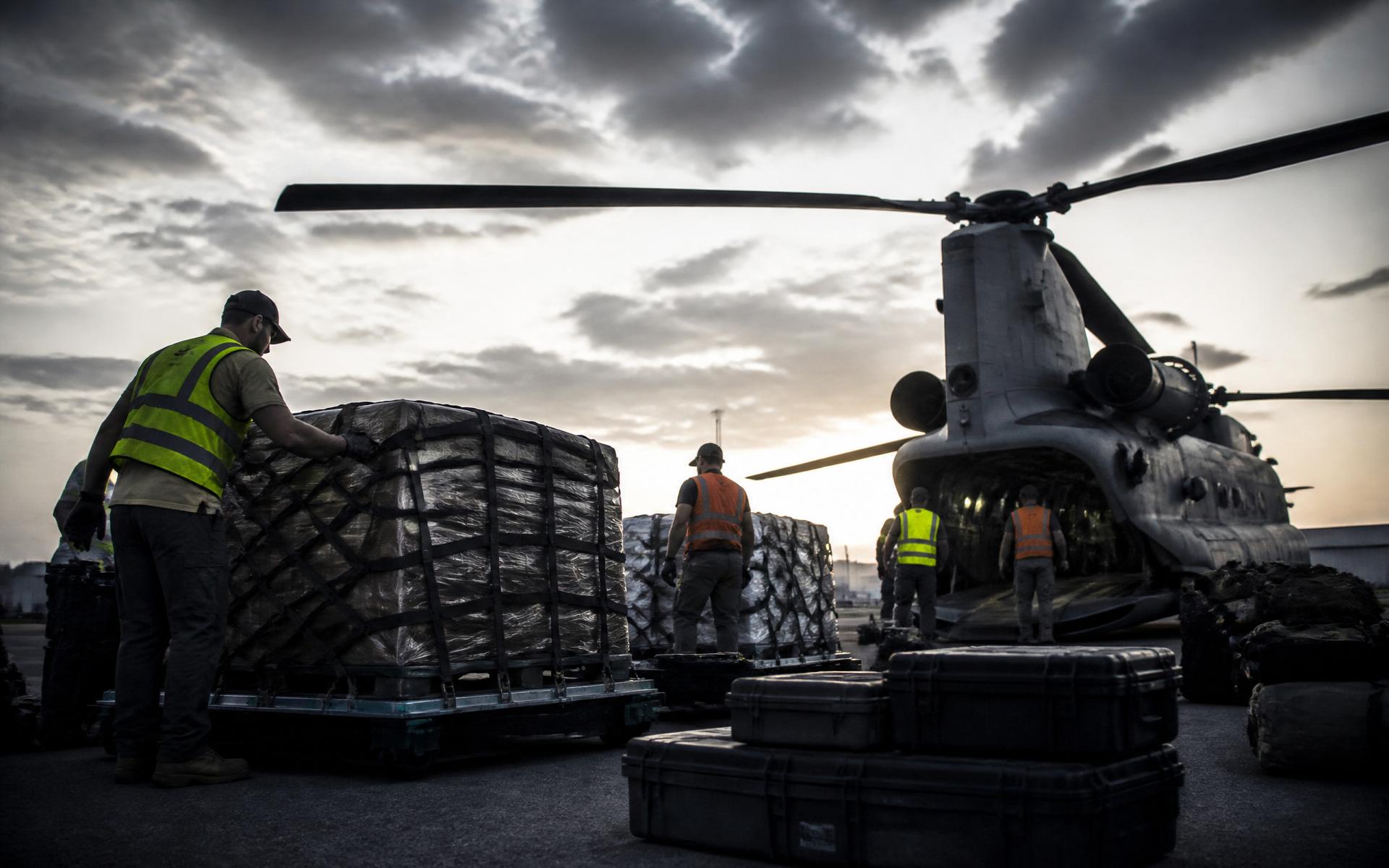 Field logistics team preparing pallets of humanitarian and operational supplies at a staging area